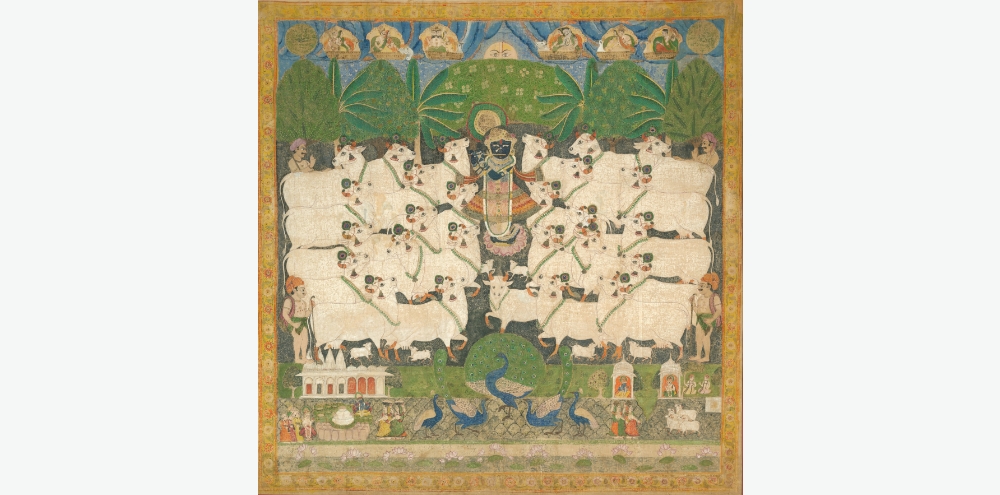 Set against the backdrop of a forest and chariots in the sky, a central dark blue-skinned figure plays the flute surrounded by a herd of cows with miniature depictions of a temple, female figures and peacocks in the foreground.