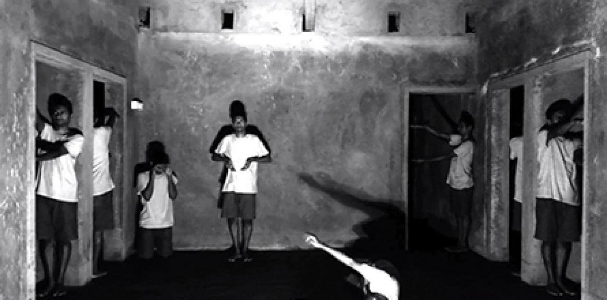 Eight manifestations of the artist pose as inanimate objects such as a newspaper, rotating table fan etc., on a screen.