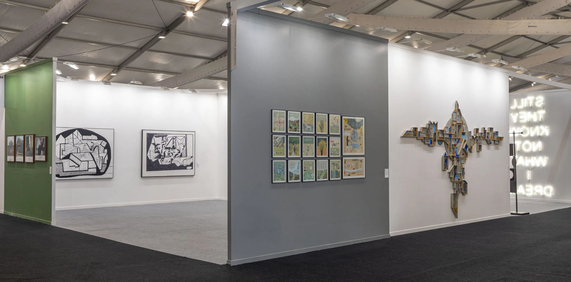 Framed large-scale artworks and installations displayed on different walls of the exhibition space.