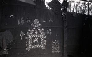  A mural depicting white, geometric figures and animals inside a pentagon structure outlined by geometric motifs